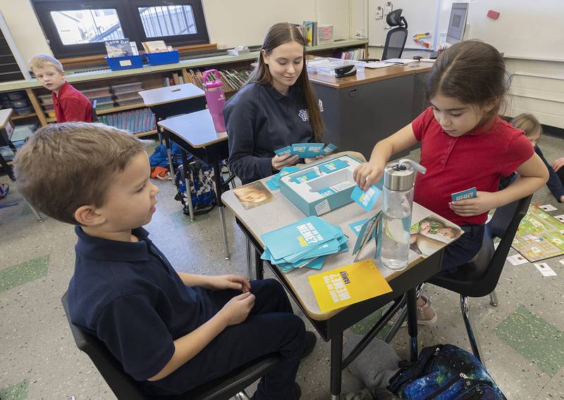 Zoe Como, a freshman at Newman, plays “Know Your Meme” with second graders Jack and Penelope Wednesday, Jan. 29, 2025, at St. Mary’s School in Dixon. NHS students visited the school to play games with the kids in celebration of Catholic Schools Week.