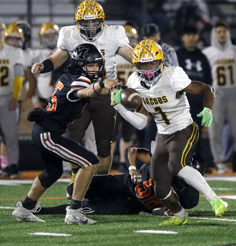 McHenry's James Butler tries to strip the ball away from Jacobs' T.O. Boddie as he runs with the ball during a Fox Valley Conference football game on Friday, Oct. 18, 2024, at McCracken Field in McHenry.