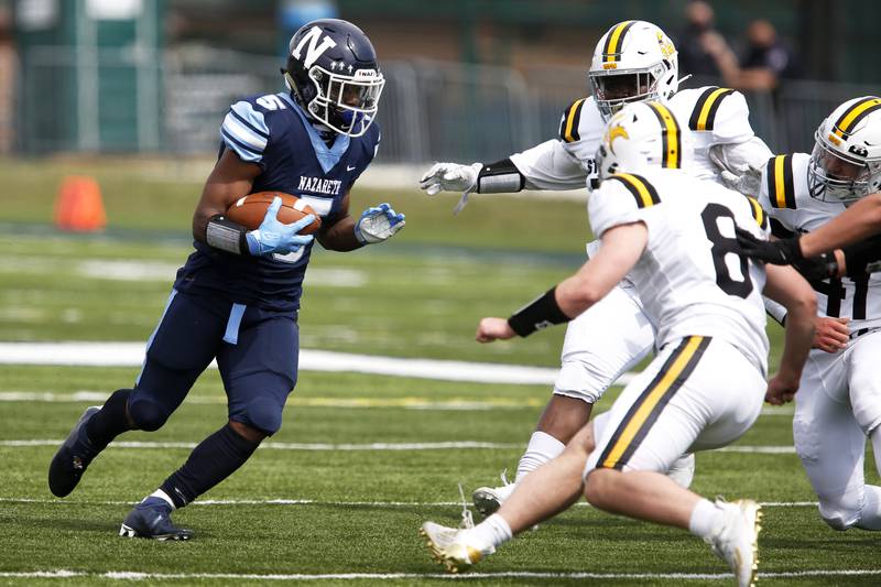 Nazareth’s Kaleb Miller carries the ball during their football game at Nazareth Academy in LaGrange Park, Ill., on Saturday, March 27, 2021.