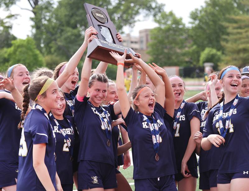 IC Catholic Prep players celebrate with their fourth place trophy after their loss to Pleasant Plains in the IHSA Class 1A state girls soccer third place game Saturday, May 27, 2023, at North Central College in Naperville.