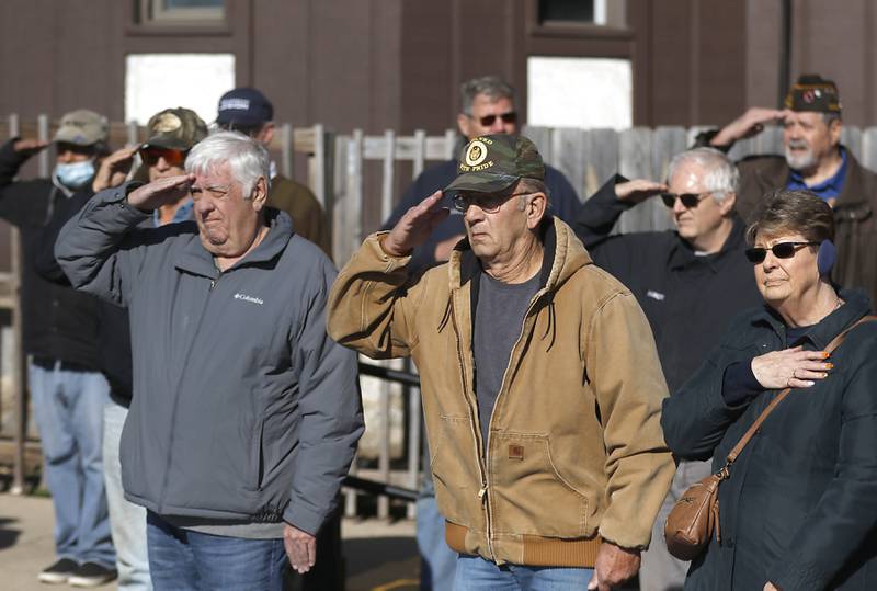 People listen to the playing of taps during a Veterans Day ceremony Friday Nov. 11, 2022, at the Woodstock Veterans of Foreign Wars Post 5040, 240 N. Throop St. The ceremony featured speeches by Woodstock Mayor Michael Turner and Post Cmdr. Fred Strauss, taps, a 21-gun salute and a luncheon.