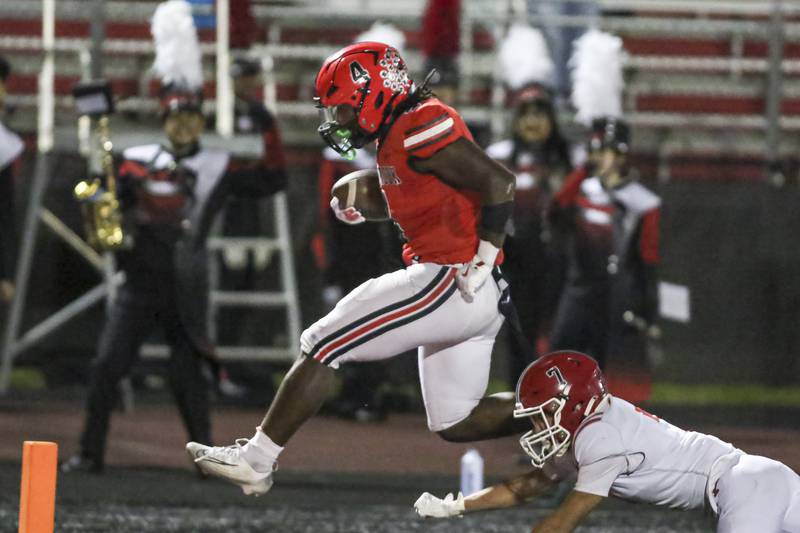 Bolingbrook's Timmie Lewis II (4) leaps into the endzone during football game between Yorkville at Bolingbrook Friday, Oct 24, 2025 in Bolingbrook.