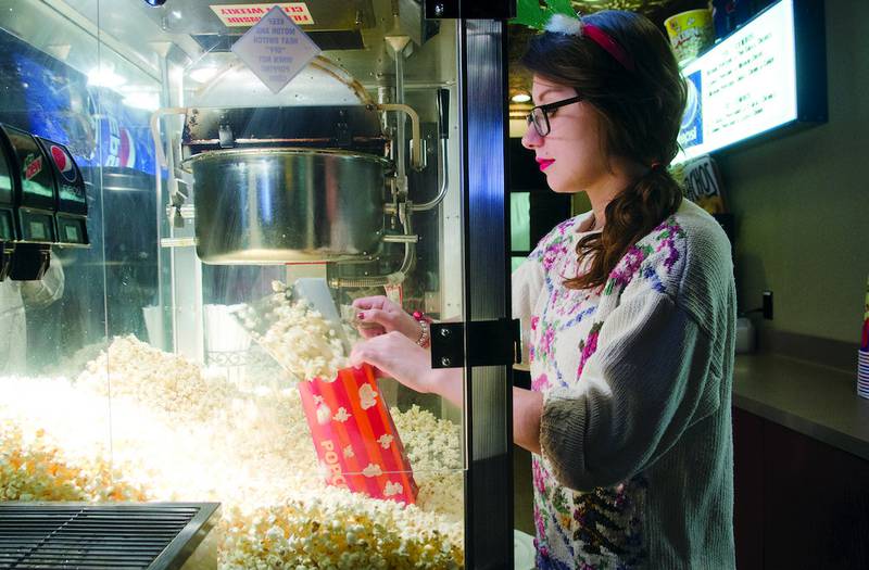 Anne Zigler of the Sterling Theater bags popcorn for customers during the "National Lampoon's Christmas Vacation" Ugly Sweater Party. The theater encouraged moviegoers to wear their most awkward holiday attire, with prizes going to the "best"-dressed patrons.