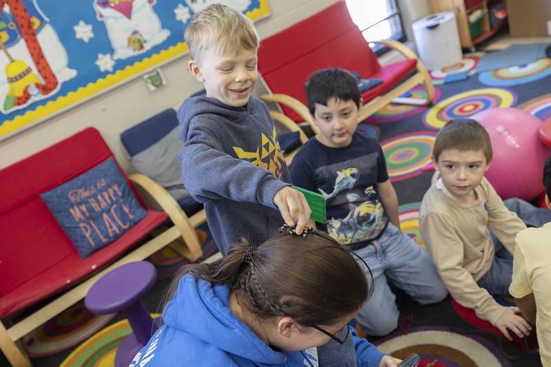 Kindergartner Oliver Wahl treats Newman Central Catholic High School junior Leah Kalina to a fake spider Thursday, Feb. 2, 2023 at St. Mary’s School. in Sterling.