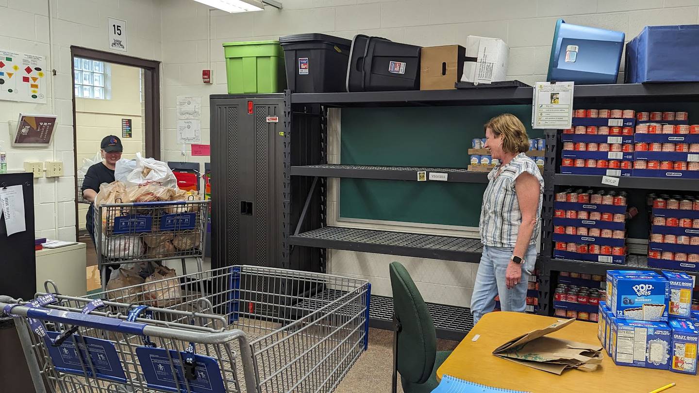 Lana Howe, president and founder of Bags of Hope (left) pulls a shopping cart of food to the hallway as Bags of Hope board member Nancy Crouch (right) takes a break on Wednesday, October 4, 2023, at Plainfield Academy. Bags of Hope is a Plainfield-based nonprofit that feeds hundreds of Will County students each weekend through a donation-funded backpack program.