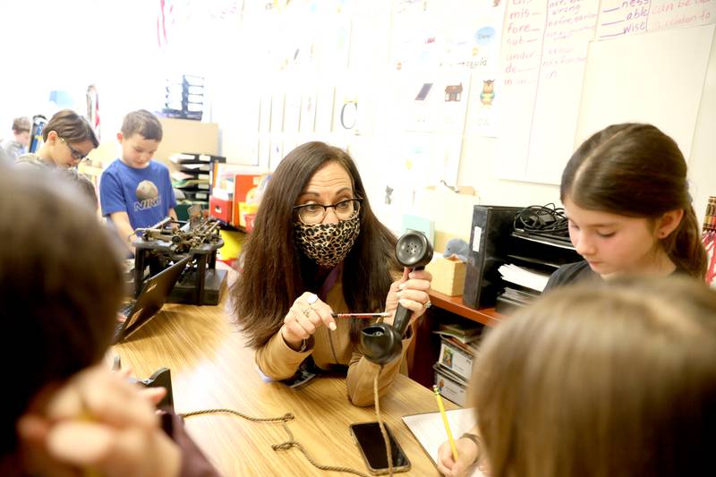 Munhall Elementary School second grade teacher Amy Fronk and her students examine historic relics such as a typewriter and rotary telephone and compared them to the present-day equivalent of a laptop computeer and cellular phone. Fronk grew up in St. Charles and attended Munhall as a student.