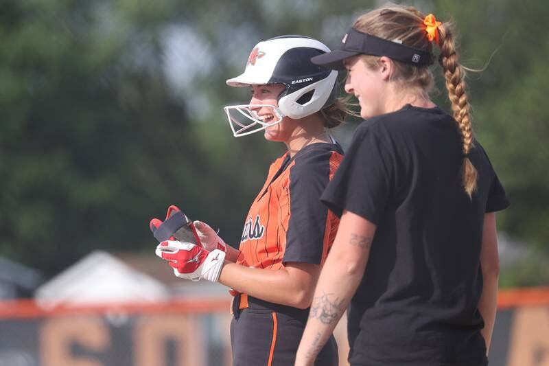 Minooka’s Taylor Mackin has a laugh with the coach after a single against Normal in the Class 4A sectional semifinal on Tuesday, May 21, 2024 in Minooka.