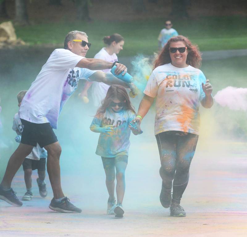 Tiffany Savage and Corra Lund, 7, of Oregon, run through the final color station at the Oregon Park District's color run on Tuesday, July 30, 2024.