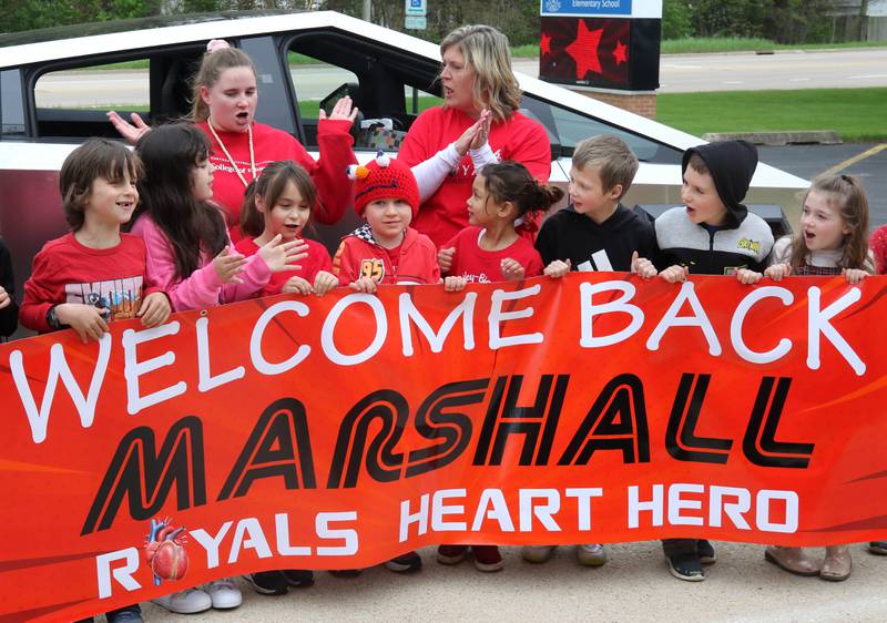 Marshall Morong, (center) 7, a first grader at Hinckley-Big Rock Elementary School, is cheered on by his classmates Monday, May 5, 2025, as he arrives for his first day back at school after missing months waiting for, and eventually receiving, heart transplant surgery at Lurie Children’s Hospital of Chicago. Morong arrived in style in a Tesla Cybertruck donated for use by Telsa of Naperville, along with an escort by Hinckley and Big Rock first responders.