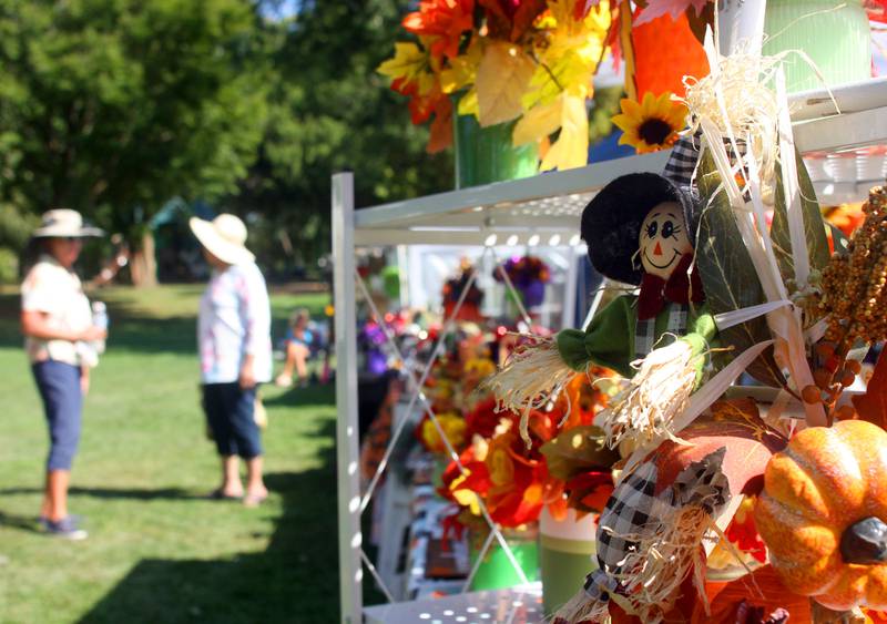 People walk past seasonal arrangements created by Brittany Rendant of Woodstock and her mother Debbie during the 20th Annual Fall Fest at Deicke Park in Huntley on Sunday, September 28, 2025.
