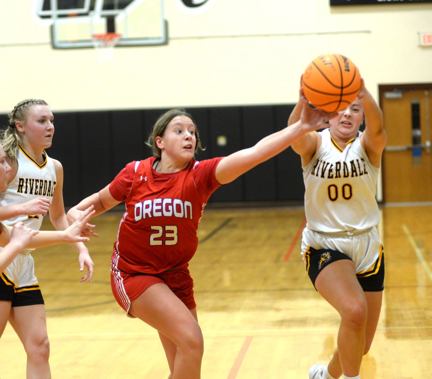 Oregon's Aniyah Sarver (23) reaches for the ball against Riverdale's Amarah Coleman (0) at the 2A Erie-Prophetstown Regional on Thursday, Feb. 20, 2025.