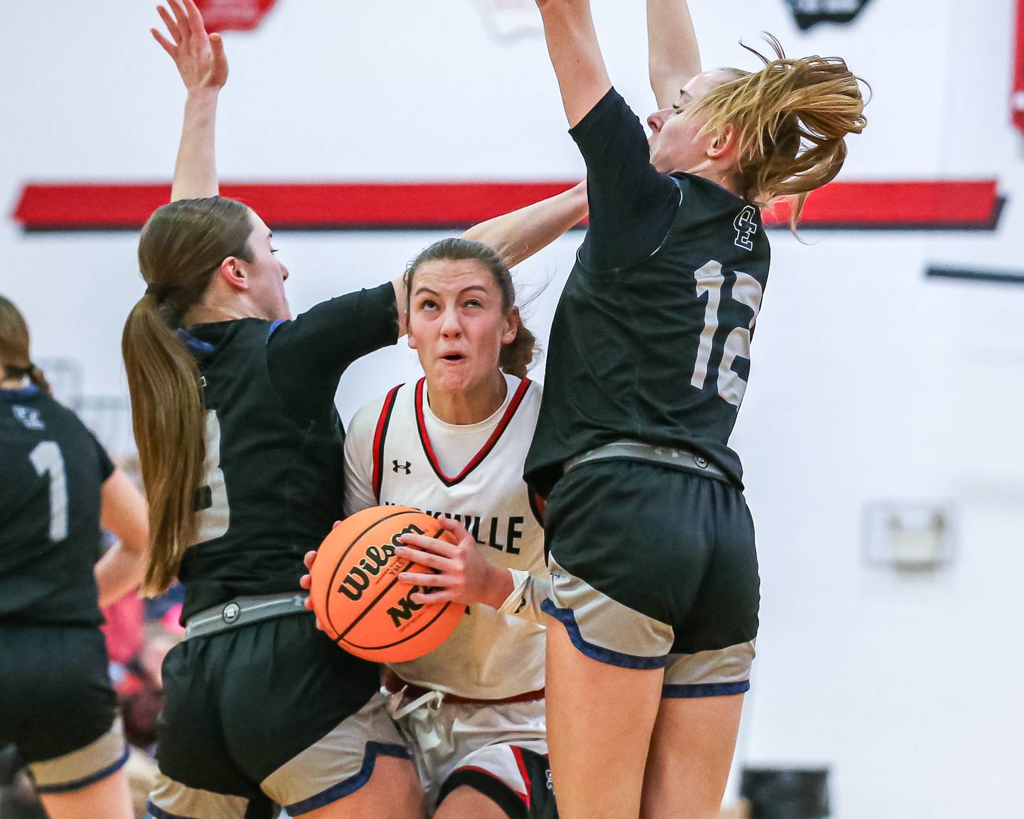 Yorkville's Lainey Gussman (12) squeezes past the Owego East defense during their basketball game between Oswego East at Yorkville, Thursday  Dec 12, 2024 in Yorkville.