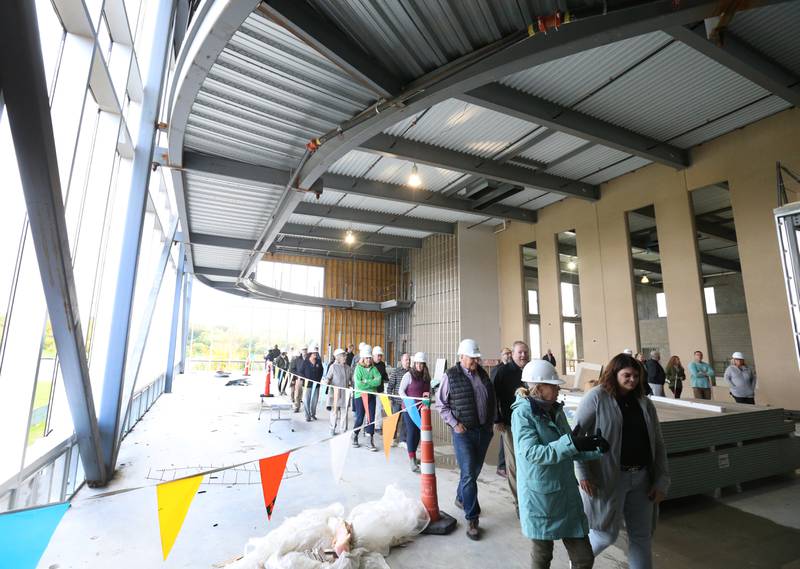 A large group walks through the wellness area inside new YMCA building on Thursday, Oct., 19, 2023 in Ottawa. The indoor walking/running track above weaves around the wellness area and above the gymnasium.