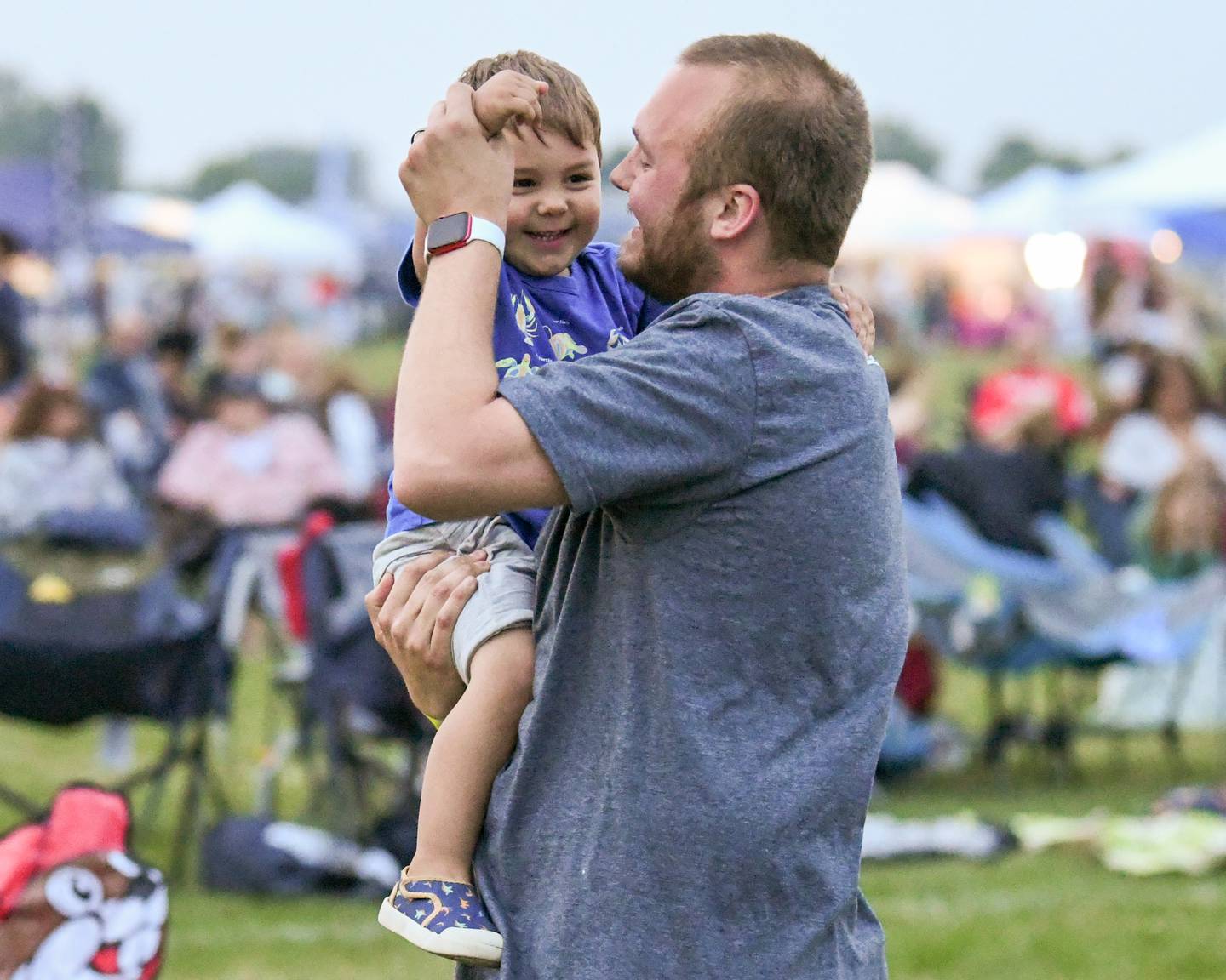 Alex Briscolino and son Bennett Briscolino, 2, of Oswego, are all smiles as they dance to the music of Marlon and the Shakes during PrairieFest on Thursday June 12, 2025, held at PrairieFest Park in Oswego.