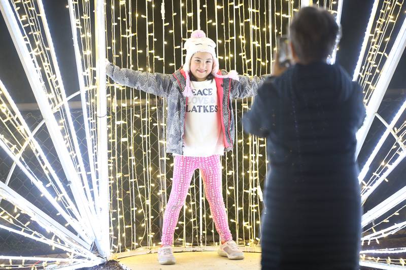 Eliza Lutz, 7, gets her photo taken at one of the holiday decorations at the GLOW Holiday Festival at Slammers Stadium on Wednesday, Nov. 27, 2024 in Joliet.
