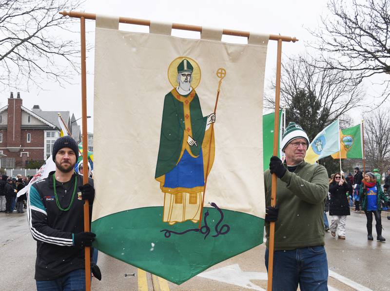 Chris Reed, left, and Lowell Bike carry a banner of St. Patrick during the St. Charles St. Patrick’s Parade Saturday, March 14, 2026.