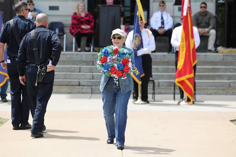 Nan Havens, of Bourbonnais, helps place wreaths on Monday, May 26, 2025, during the Kankakee County Veterans' Council annual Memorial Day Ceremony at the Kankakee County Courthouse. Havens and her husband, Tim Rehmer, write veteran-themed songs, which Rehmer performed at the ceremony.