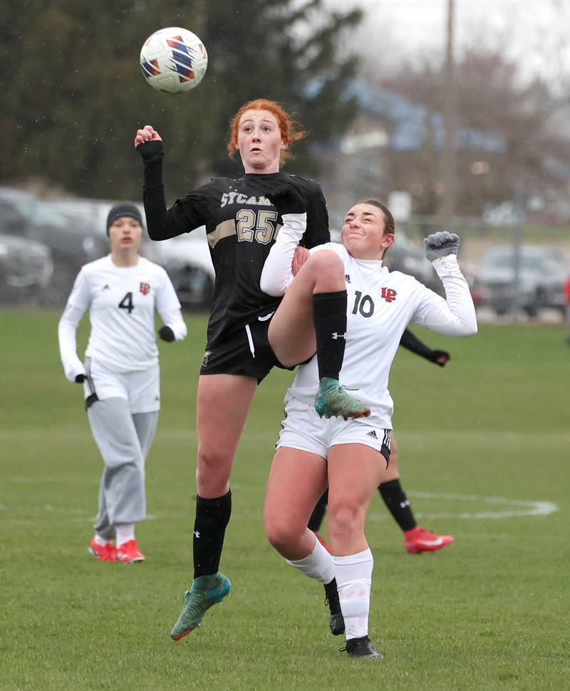 Sycamore's Izzie Segreti and La Salle-Peru's Kendal Bassett go up for a ball during their game Wednesday, April 9, 2025, at Sycamore High School.
