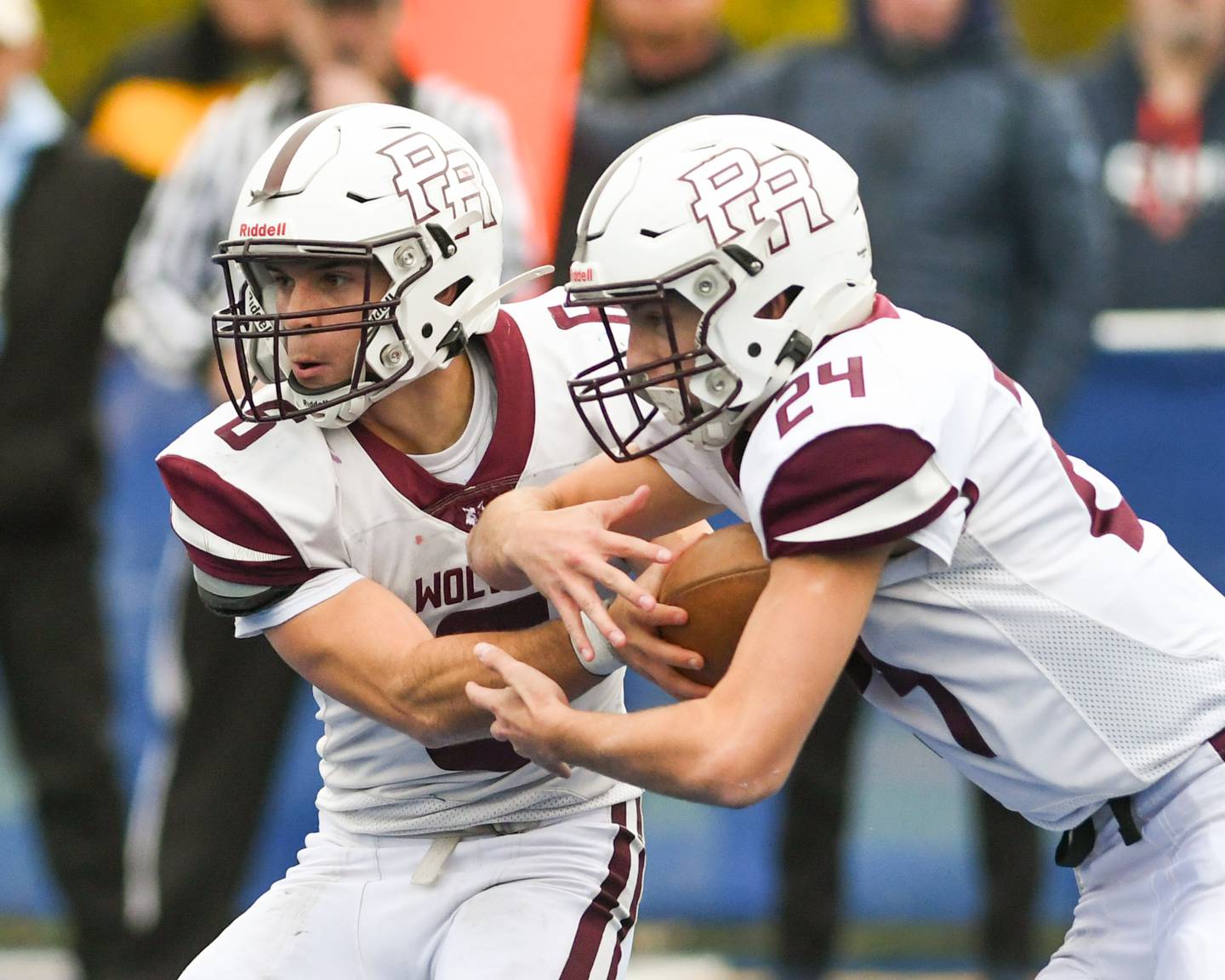 Prairie Ridge's Luke Vanderwiel (6) hands the ball off to teammate Vincent Byk (24) for a 64-yard gain while traveling to take on St. Francis in the second round of the 5A playoff game on Saturday Nov. 8, 2025, held at St. Francis's High School.