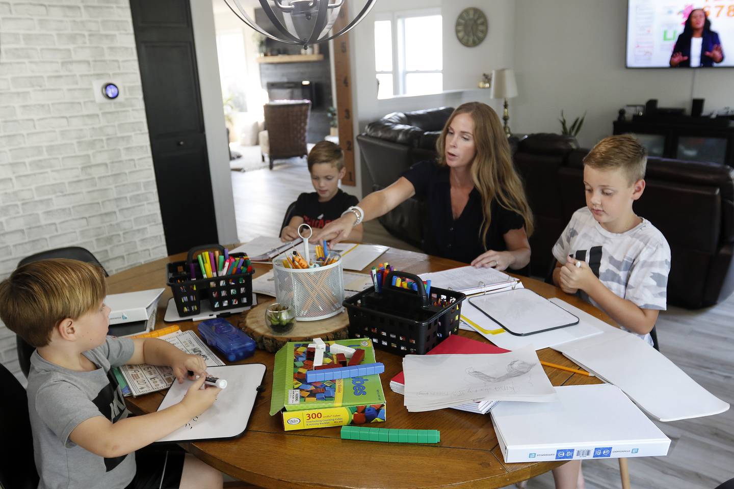 Jessica Clements helps her sons (from left:) Dayne, 4, Gavin, 7, and Myles, 10, during a homeschool session with learning materials from The Good and The Beautiful at home on Tuesday, Aug. 17, 2021 in McHenry.  This is the family's first time trying home schooling.  Myles is in 5th grade, Gavin is in 2nd, and Dayne, 4, is in preschool.