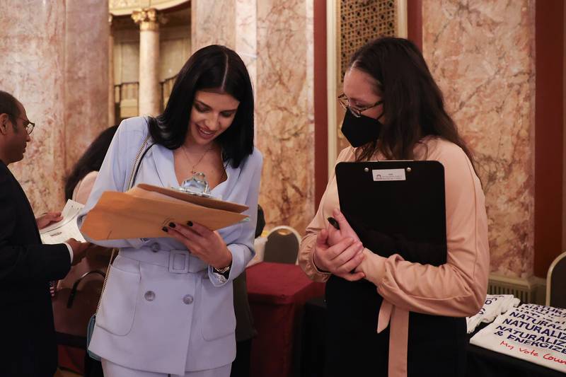 New appointed U.S citizen Cristina Critoru, from Moldova, registers to vote at the Special Naturalization Ceremony held at the Rialto Square Theatre in downtown Joliet on Tuesday, April 23, 2024.