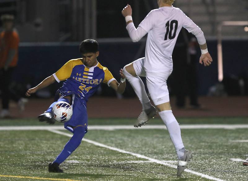 Chicago De La Salle's Bryan Tamayo kicks the ball away from a charging Prairie Ridge's Chase Santucci during an IHSA Class 2A state semifinal soccer match on Friday, Nov. 8, 2024, at Hoffman Estates High School.