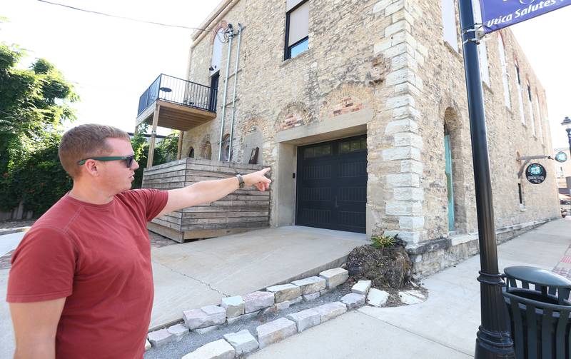 Dan Stash points to a retractable door that will he hopes to turn the space into an outdoor bar area behind the Bickerman building on Wednesday, Aug. 24, 2022 in Utica.