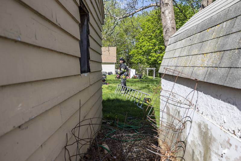 Firefighters train in the back of a home on West Second Street Wednesday, May 1, 2024 in Rock Falls. The home was bought by the health department and will be demolished to make room for a new parking lot. In the meantime, fire departments from Sterling and Rock Falls used the house for training.