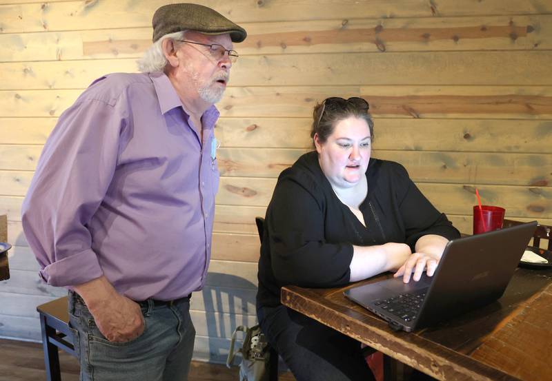 Kori Rempfer, chair of the DeKalb County Democratic Party, and Stewart Ogilvie, candidate for County Board District 4, check to see if any election results have posted Tuesday, June 28, 2022, during a Democrat candidate watch party at Fatty's Pub and Grille in DeKalb.