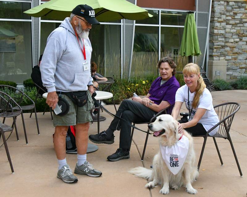 Sharon Smith, right, of Geno pets Joey the golden retriever from Canine 4 Christ while talking with handler Dick Hilderbrant on Sunday Sept. 21, 2025, before the start of the Be the One Walk held at the Kishwaukee Health & Wellness Center in Sycamore.