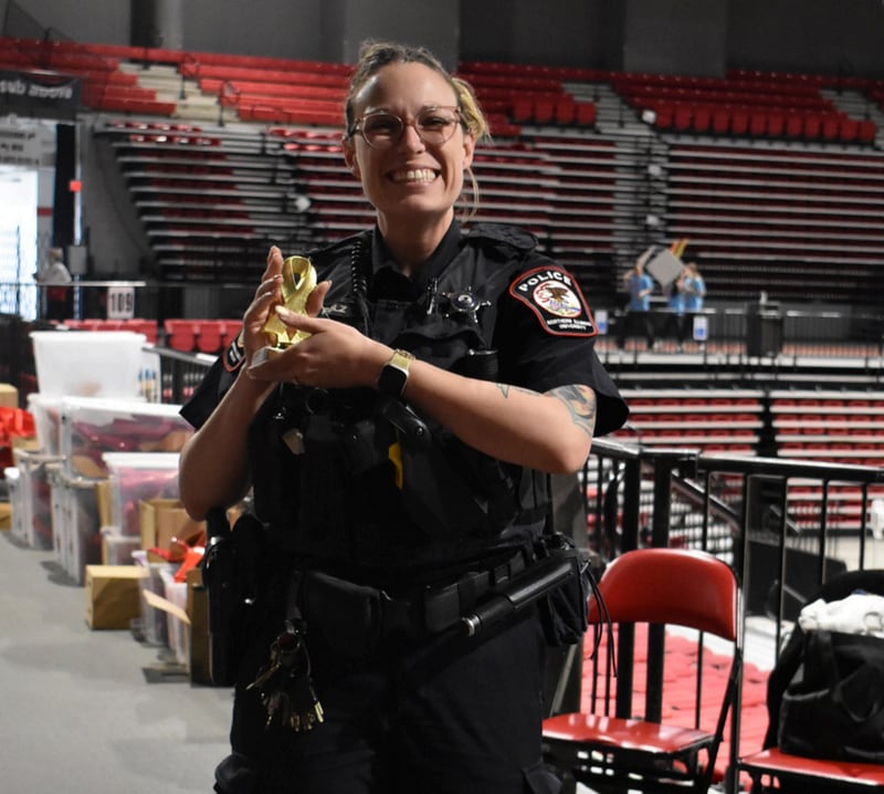 A DeKalb police officer poses for a photo at Safe Passage's annual Walk A Mile in Their Shoes event on April 18, 2026, at the Northern Illinois University Convocation Center in DeKalb. The event, held to raise awareness of sexual violence and supoprt survivors, was hosted by the nonprofit as part of Sexual Assault Awareness Month.