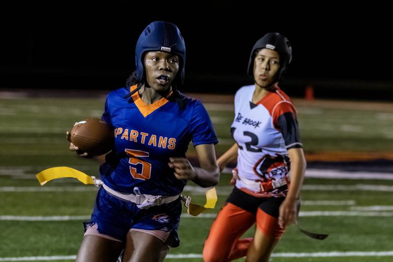 Romeoville's Jamiah Player picks-up yardage during a varsity flag football Romeoville Regional semifinal game at Romeoville on Oct. 7, 2025.