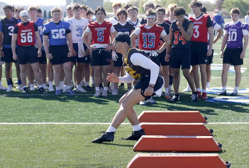 Players watch Jacobs' Austin Stennett runs an agility drill at the Northern Burbs Football Showcase on Monday, May 4, 2026, at Johnsburg High School. Over 165 players from 15 teams demonstrated their football skills to over 60 college coaches.
