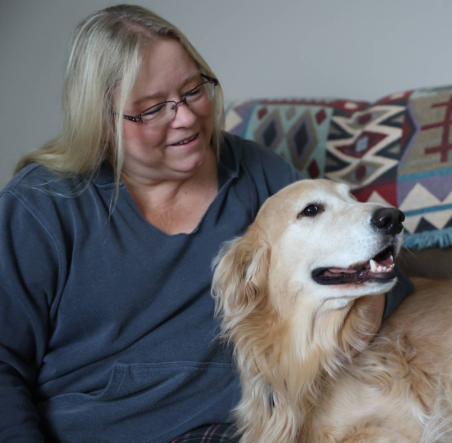 Kathy Vanoskey sits with Teddy, 4, on the couch in her Minooka home. Vanoskey is raising money to pay for Teddy's surgery, a repair of the canine version of a torn ACL.