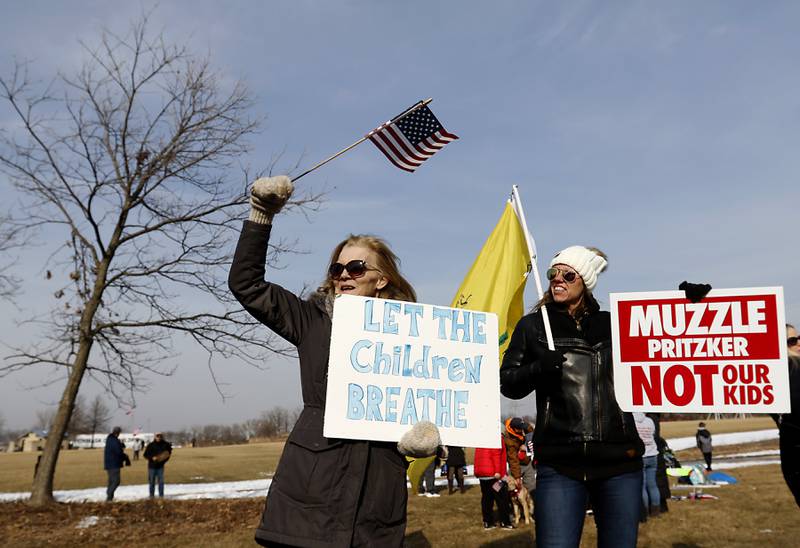 Cindy Johnson, of Cary, and Ame Greco, of Crystal Lake, protest during a District 26 Unmask The Children Community Rally Tuesday, Feb. 15, 2022, along Three Oaks Road at Cary Grove Park. The event was attend by about 100 people and organized by the Illinois Parents Union Cary.