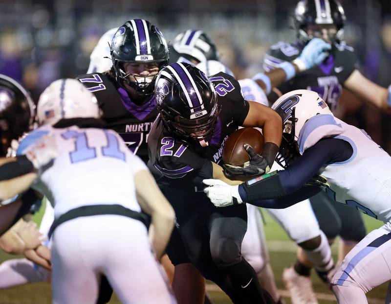 Downers Grove North's Kevin Jay Jr.  (27) barrels through the line on his way upfield during the IHSA Class 7A playoff football game Friday, Oct. 31, 2025 in Downers Grove.