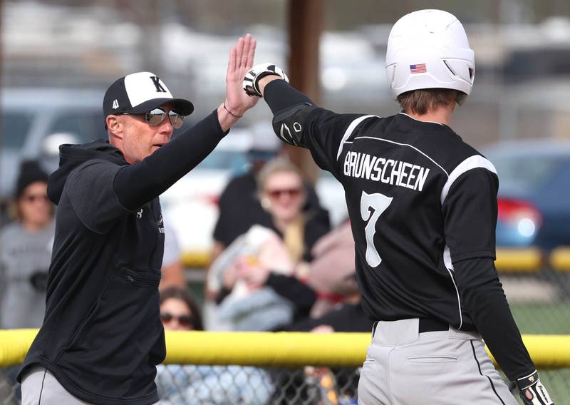 Kaneland head coach Brian Aversa greets Matthew Brunscheen after he tripled during their game against Sycamore Monday, April 22, 2024, at the Sycamore Community Sports Complex.