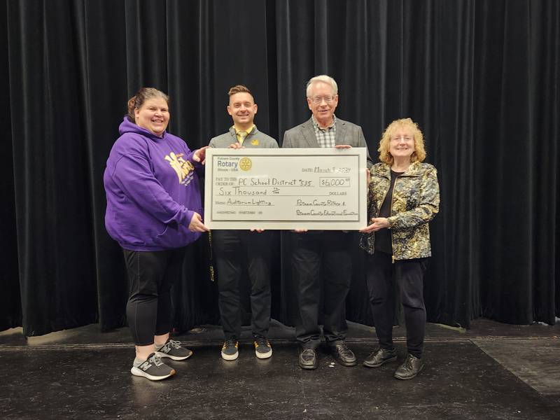 (From left) Music/Theatre Director Natalie Hulstrom and Putnam County Community School District Superintendent Clayton Theisinger receive a combined donation of $6,000 donation from Putnam County Educational Foundation Board Chair Reed Wilson and Putnam County Rotary President Adriane Shore. The combined donation will help fund renovation of the high school auditorium’s stage lighting system.