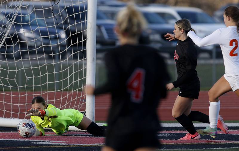 Crystal Lake Central's Ryleigh Smith reaches for the ball after blocking as shot as Huntley's Maizie Nickle runs towards the ball during a Fox Valley Conference  soccer match on Tuesday, April 15, 2025, at Huntley High School.