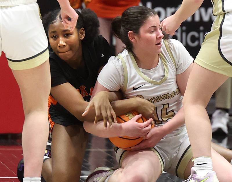 DeKalb's Johnna Patrick and Sycamore's Norah Chami fight for a loose ball during their game Friday, Jan. 31, 2025, in the FNBO Challenge in the Convocation Center at Northern Illinois University in DeKalb.