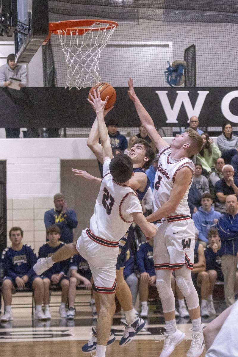 Denver Trainor of Marquette puts up a shot against Nick Plesko and Jon Moore of Woodland during the varsity game on January 30, 2024.