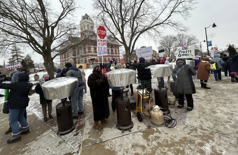 Attendees at Indivisible of Ogle County's protest warm themselves at warming stations on Sunday, Jan. 25, 2026 as temperatures dipped into the single digits with below zero windchills.