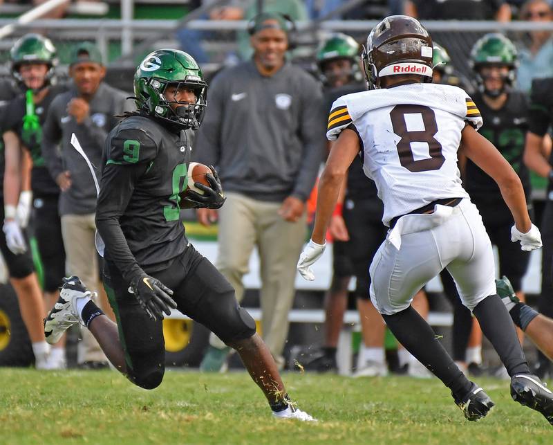 Glenbard West’s Jaylen McMiller (9) runs the ball as Joliet Catholic’s Michael Brown (8) defends during a game on September 6, 2025 at Glenbard West High School in Glen Ellyn.