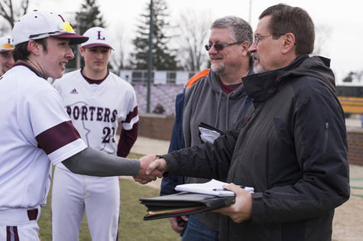 Joliet Herald News  sports reporter Dick Goss shakes hands with Lockport's MVP of the game, Collin Woulfe Saturday, March 31, 2018, at Ed Flink Field in Lockport, Ill.