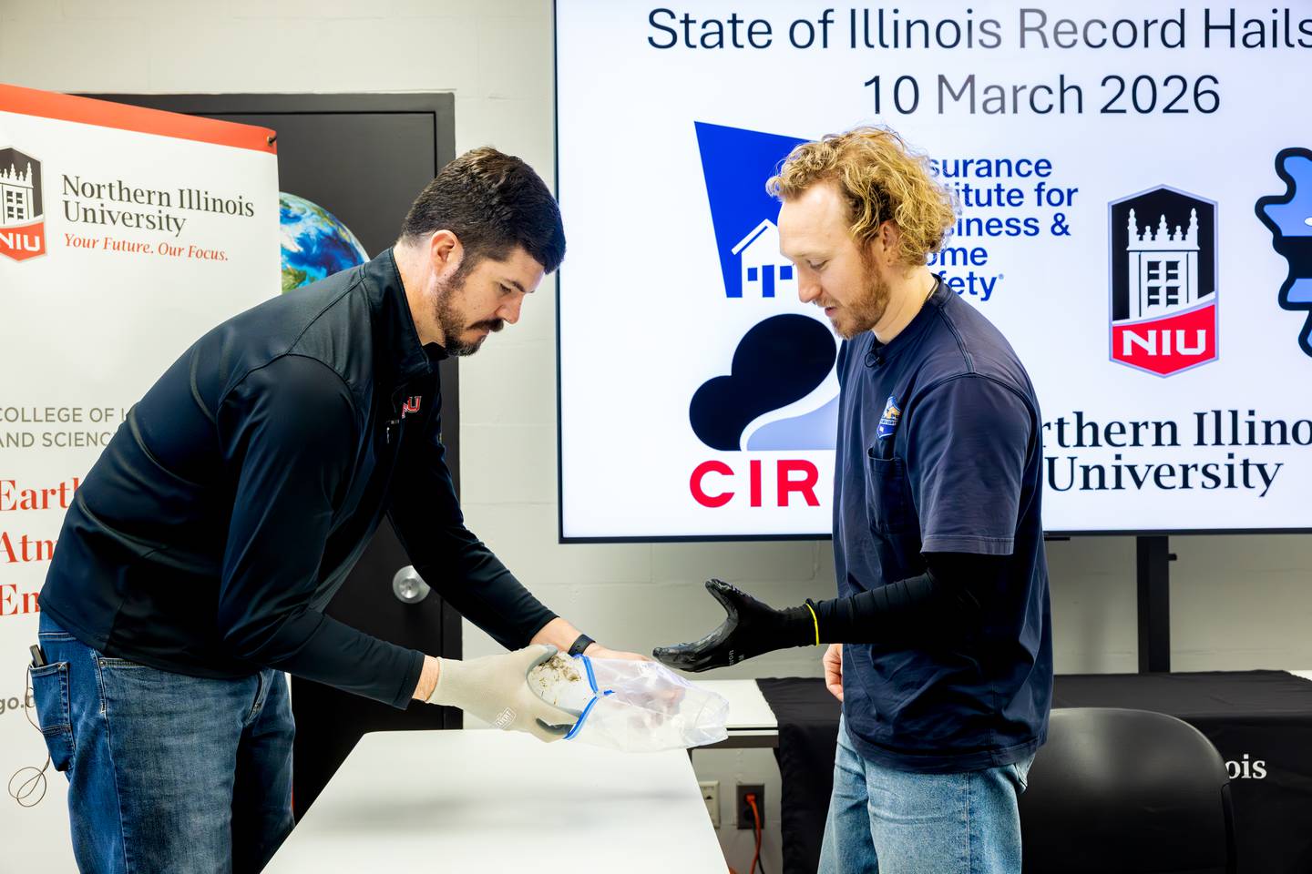 NIU professor and meteorologist Victor Gensini (left) and Lucas Faulkner of the Insurance Institute for Business and Home Safety, work together on Tuesday, March 17, 2026, in DeKalb, to measure a massive hailstone collected from a severe storm in Kankakee County on March 10, 2026. The stone was 6.6 inches wide and weighed nearly 20 ounces, likely a state record once certified, according to NIU.