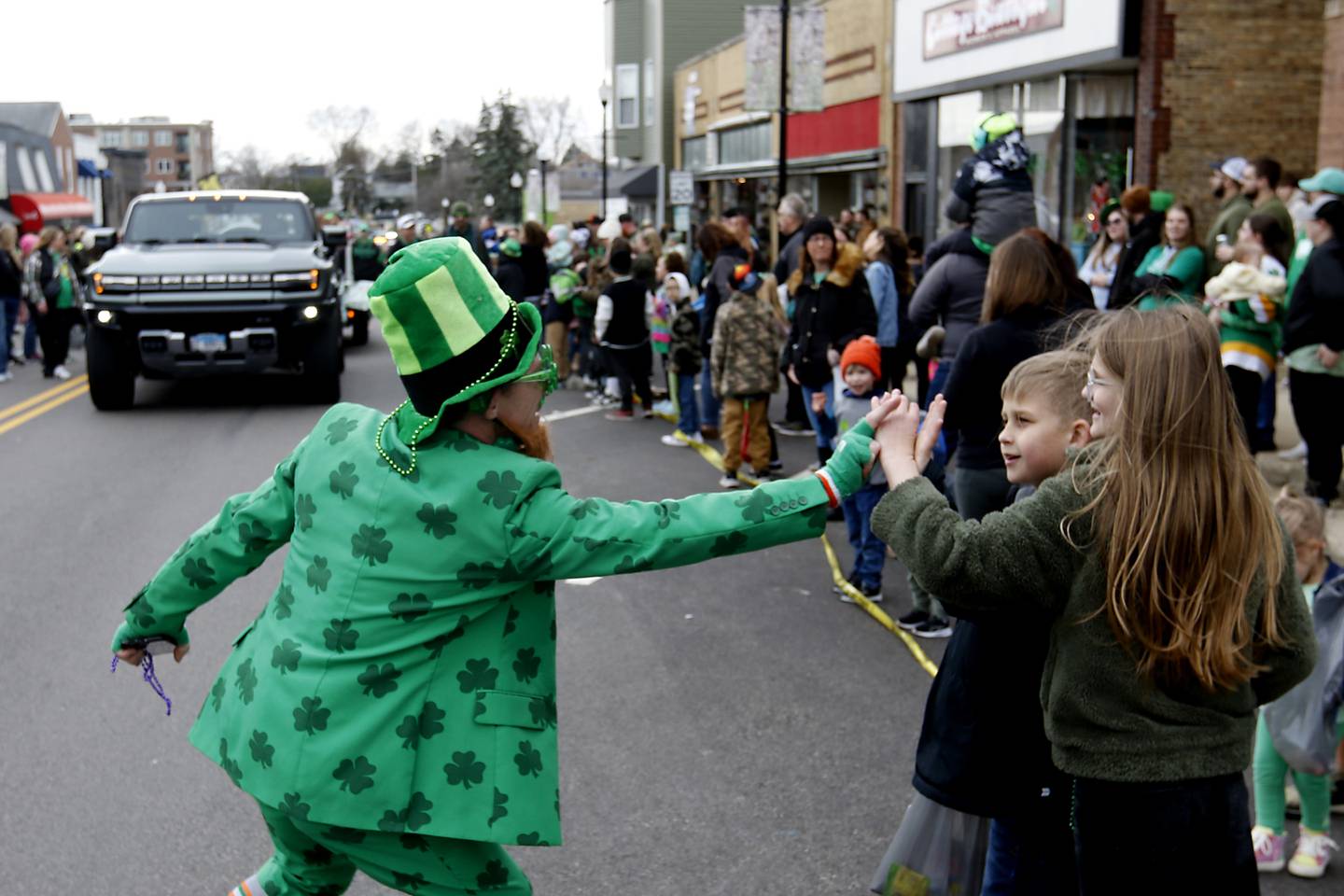 David Mulick, dressed as a Leprechaun high fives parade goers during the McHenry ShamROCKS the Fox Festival Parade on Saturday, March 16, 2024.