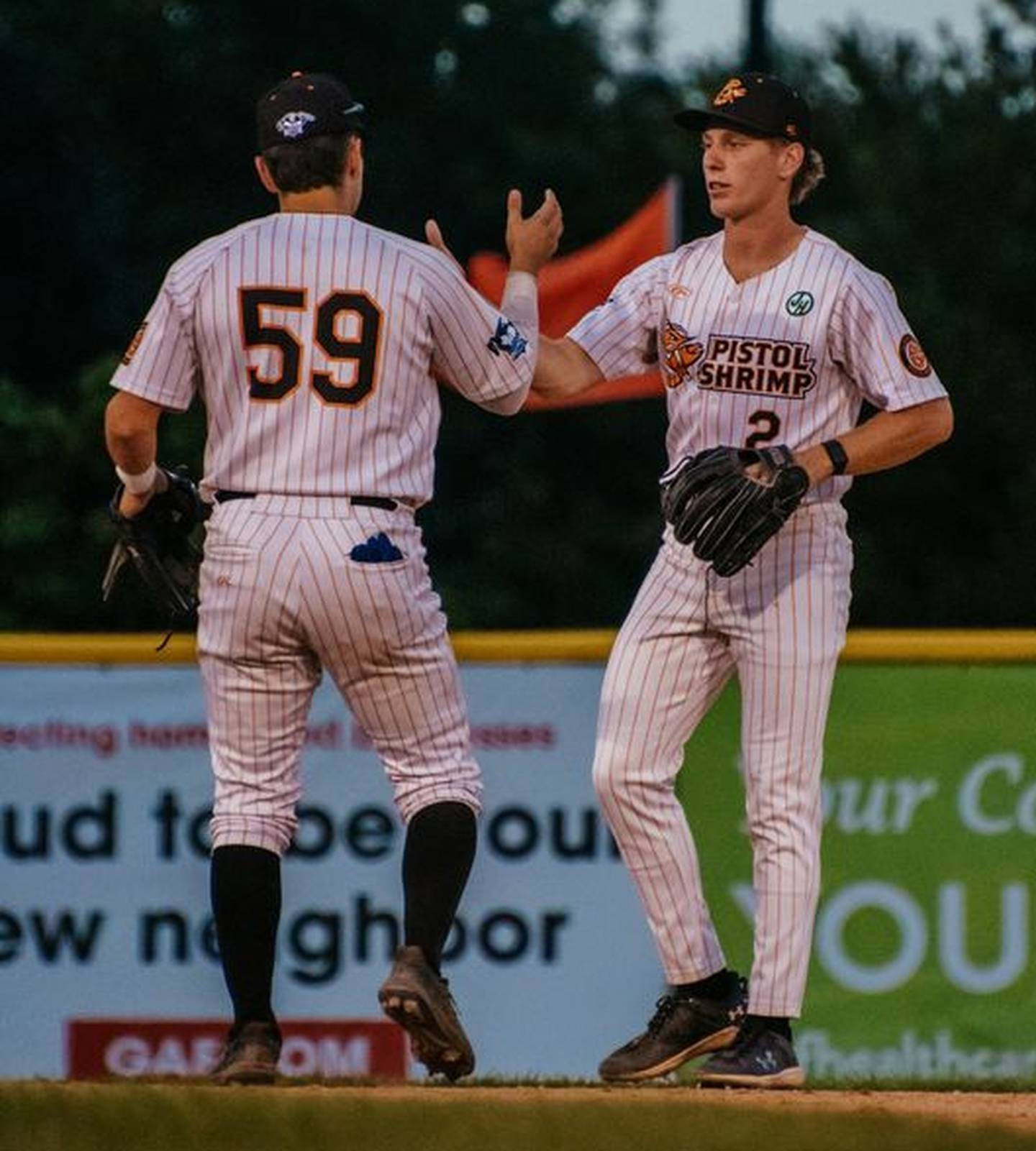 Chance Resetich (right) and Chris Esquivel high five during the Illinois Valley Pistol Shrimp's victory over the Thrillville Thrillbillies earlier this season at Schweickert Stadium in Peru.