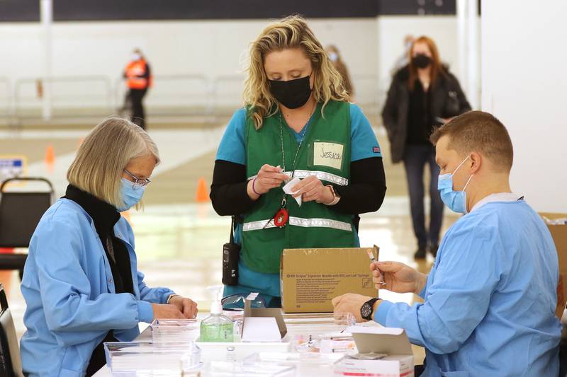 Workers prepare Moderna COVID-19 vaccinations Tuesday, March 2, 2021, during a COVID-19 vaccination clinic through the McHenry County Department of Health at 1900 N. Richmond Road, the former site of a Kmart in McHenry.  Vaccinations are made by appointment only.