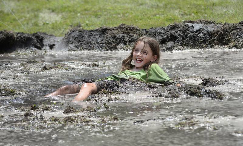 Gracie Martin, 8, of Prophetstown, flops in the mud during a mud volleyball game at Hooppole Fun Day on Saturday, June 28, 2025 in Hooppole.