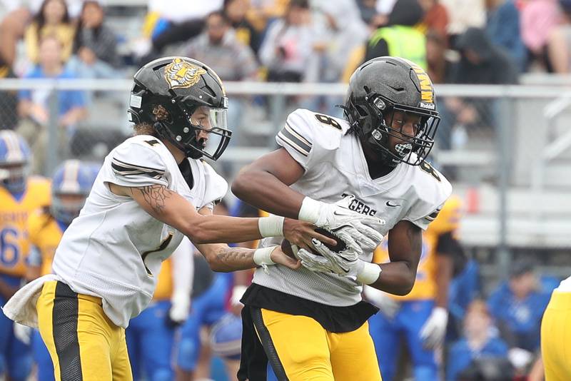 Joliet West’s Antonio Brooks hands the ball off to Taivaughn Johnson against Joliet Central on Saturday, Sept. 28, 2024 in Joliet.